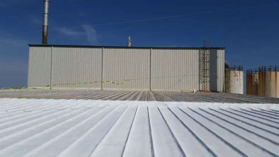 a large white building with a white roof and a blue sky in the background