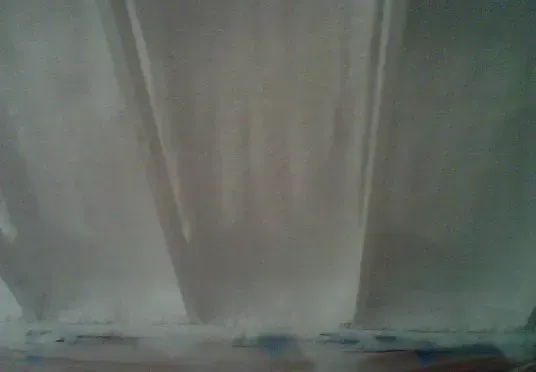 a close up of a white curtain hanging on a door