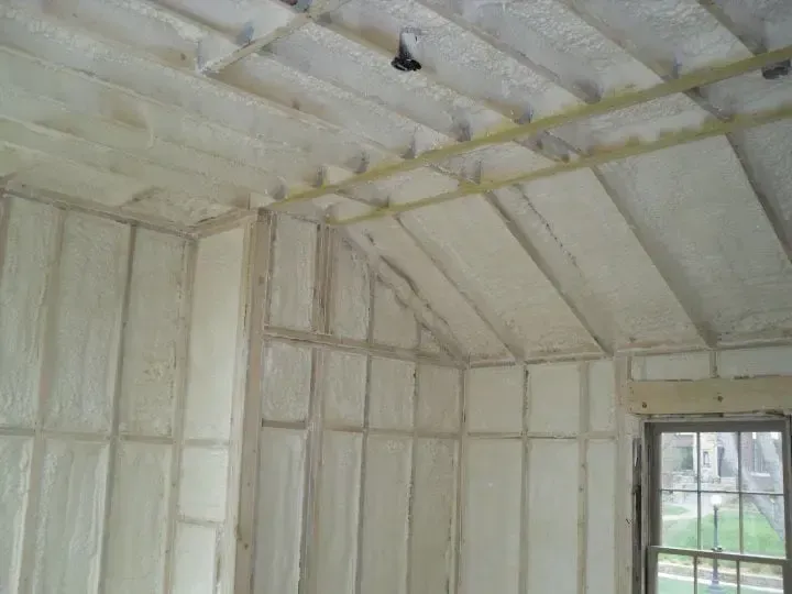 a room with a ceiling that is covered in foam and a window .