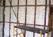 a scaffolding is sitting in front of a wall with foam insulation