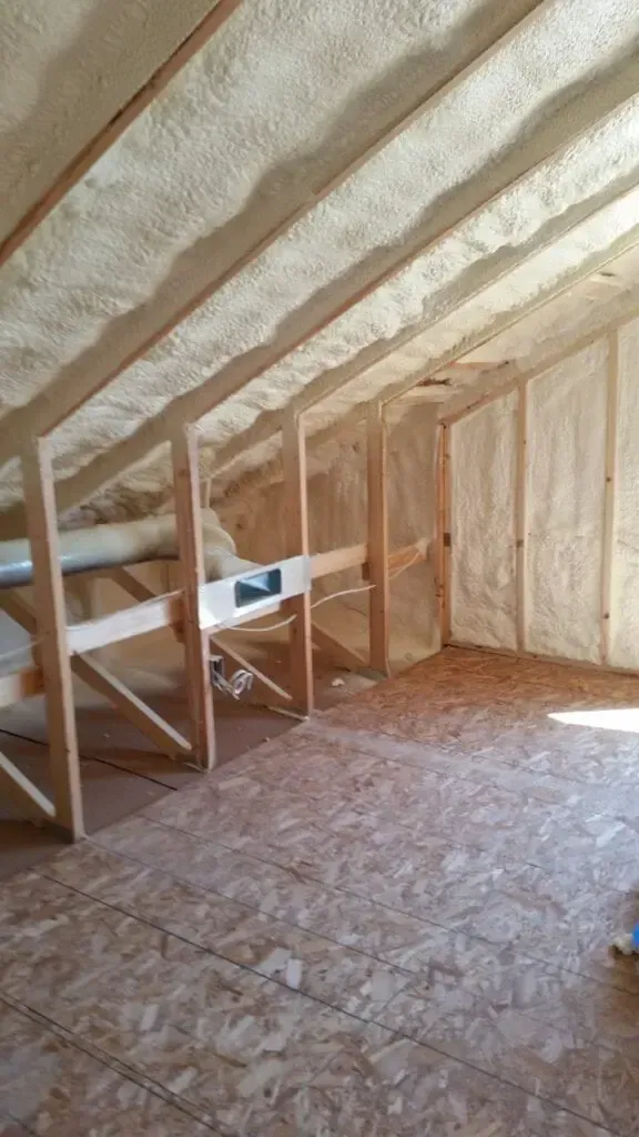 an attic with a lot of insulation on the ceiling and walls