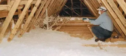 a man is blowing insulation into the attic of a house