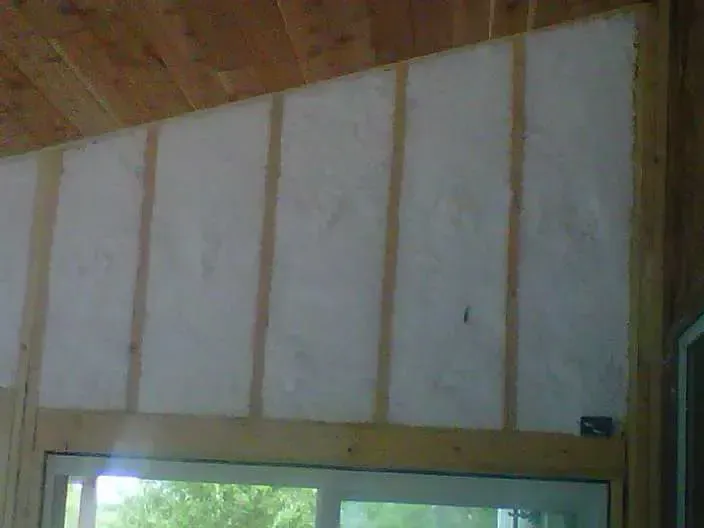 a room with a window and a wall with insulation on it