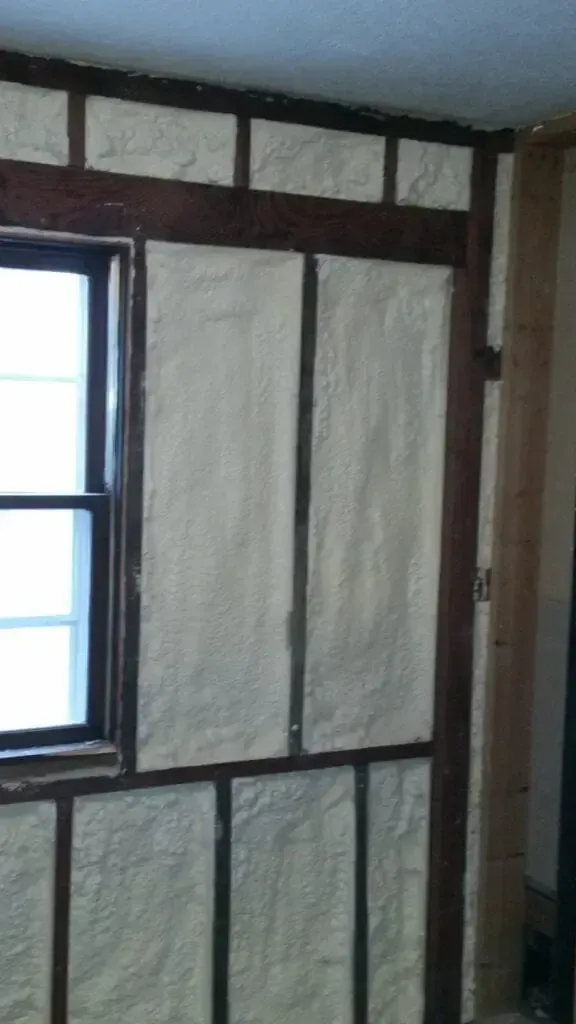 a room with a window and a wall covered in insulation .