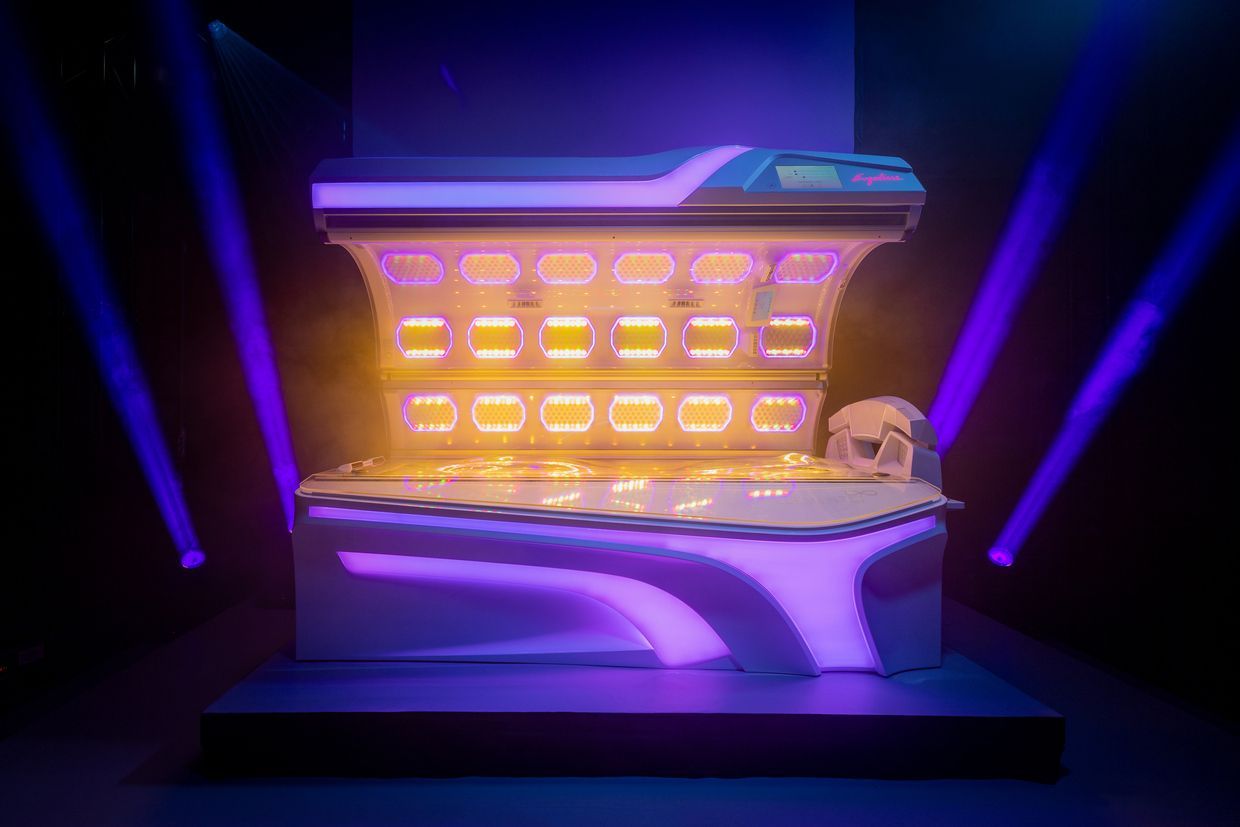 Neon-lit futuristic vault or chest with glowing orange compartments against a purple stage background