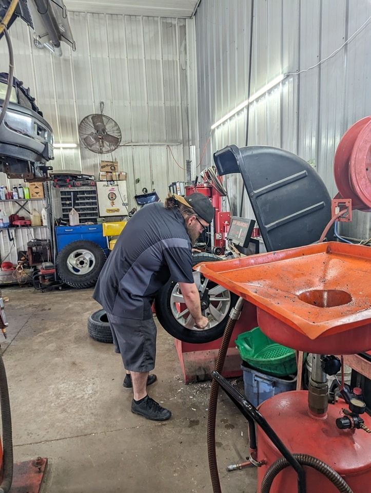 Mechanic balancing a car tire in an auto shop.