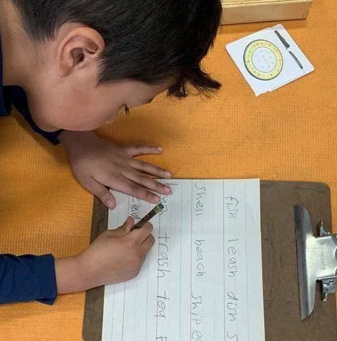 A child is reading a book that says it 's okay to be