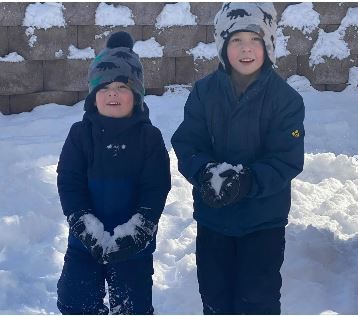 Two young boys standing in the snow 