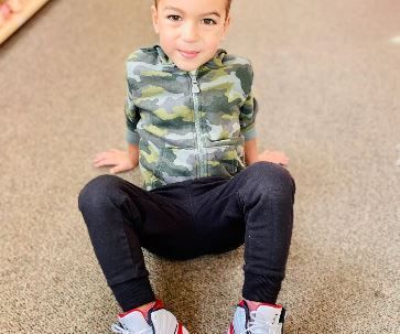 A young boy is sitting on the floor 