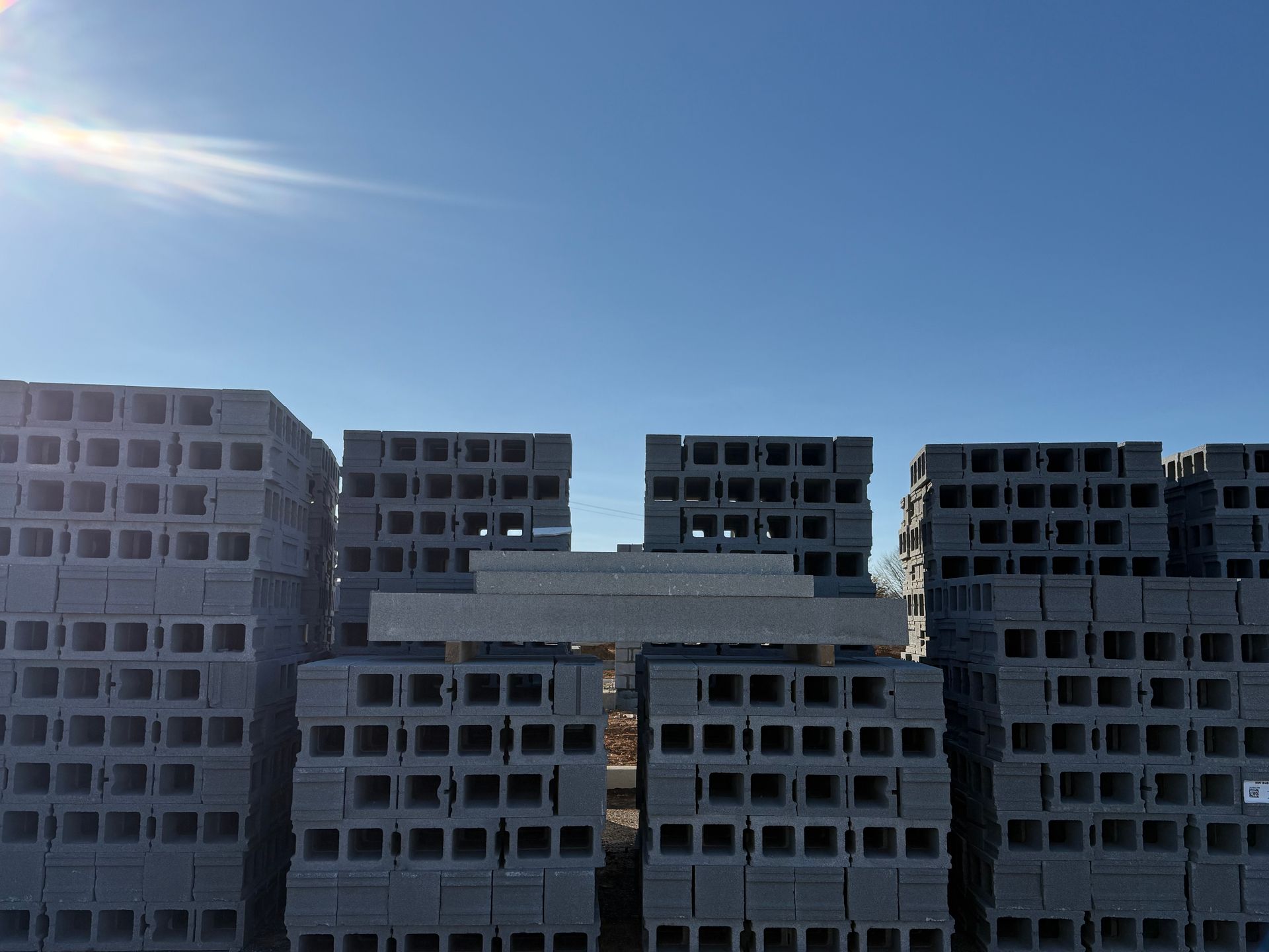 Construction site with several unfinished apartment buildings under a clear blue sky