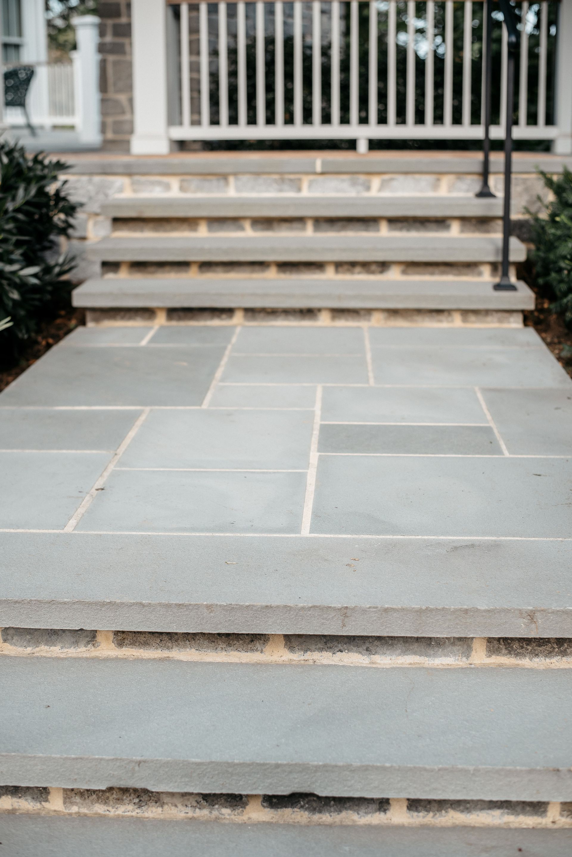 Stone front steps with a small landing leading to a porch entrance