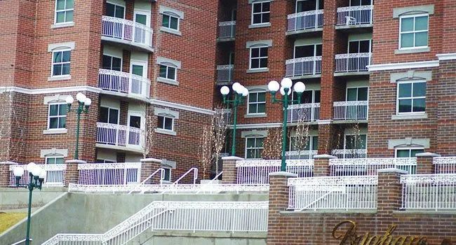Brick apartment building with balconies and a snowy courtyard with white railings