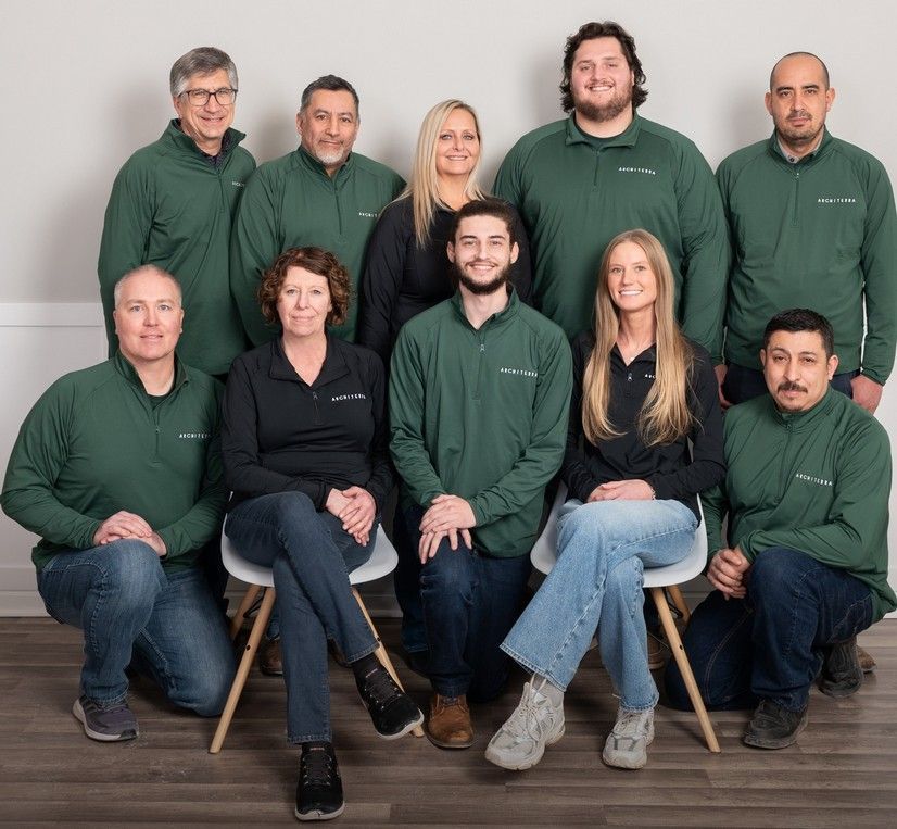 Group of people in green and black shirts posing indoors.