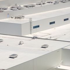 An aerial view of a large building with a white roof