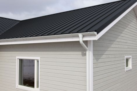 A house with a black roof and white siding