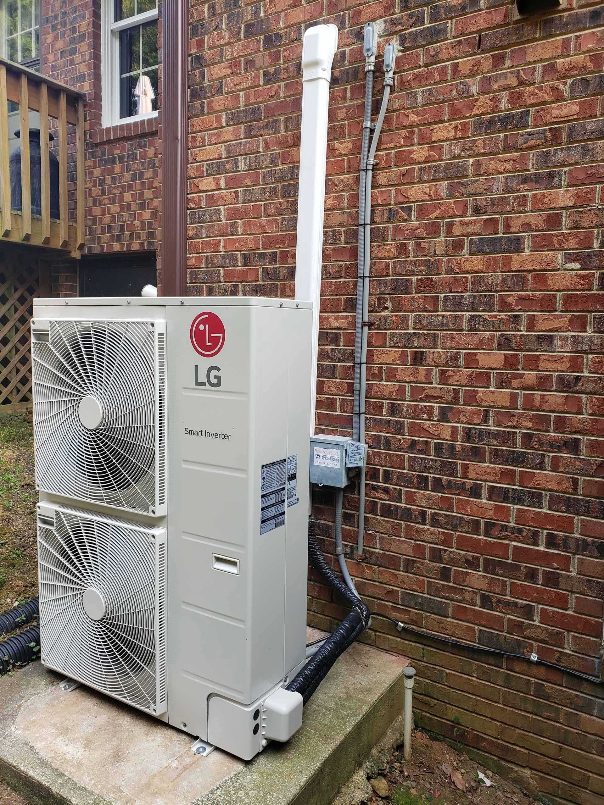 LG outdoor HVAC unit next to a brick wall. A gas line and vent pipe are also present.