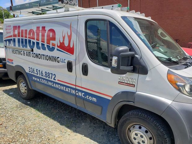 White Fluyette Roofing & HVAC van parked outside. Contains company contact info.