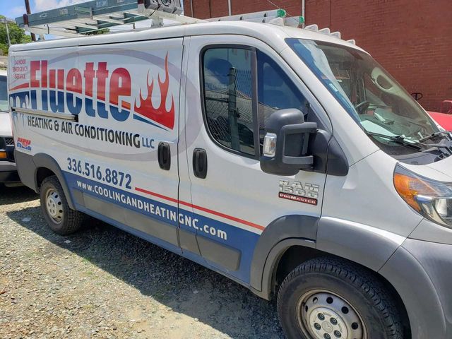White Fluyette Roofing & HVAC van parked outside. Contains company contact info.