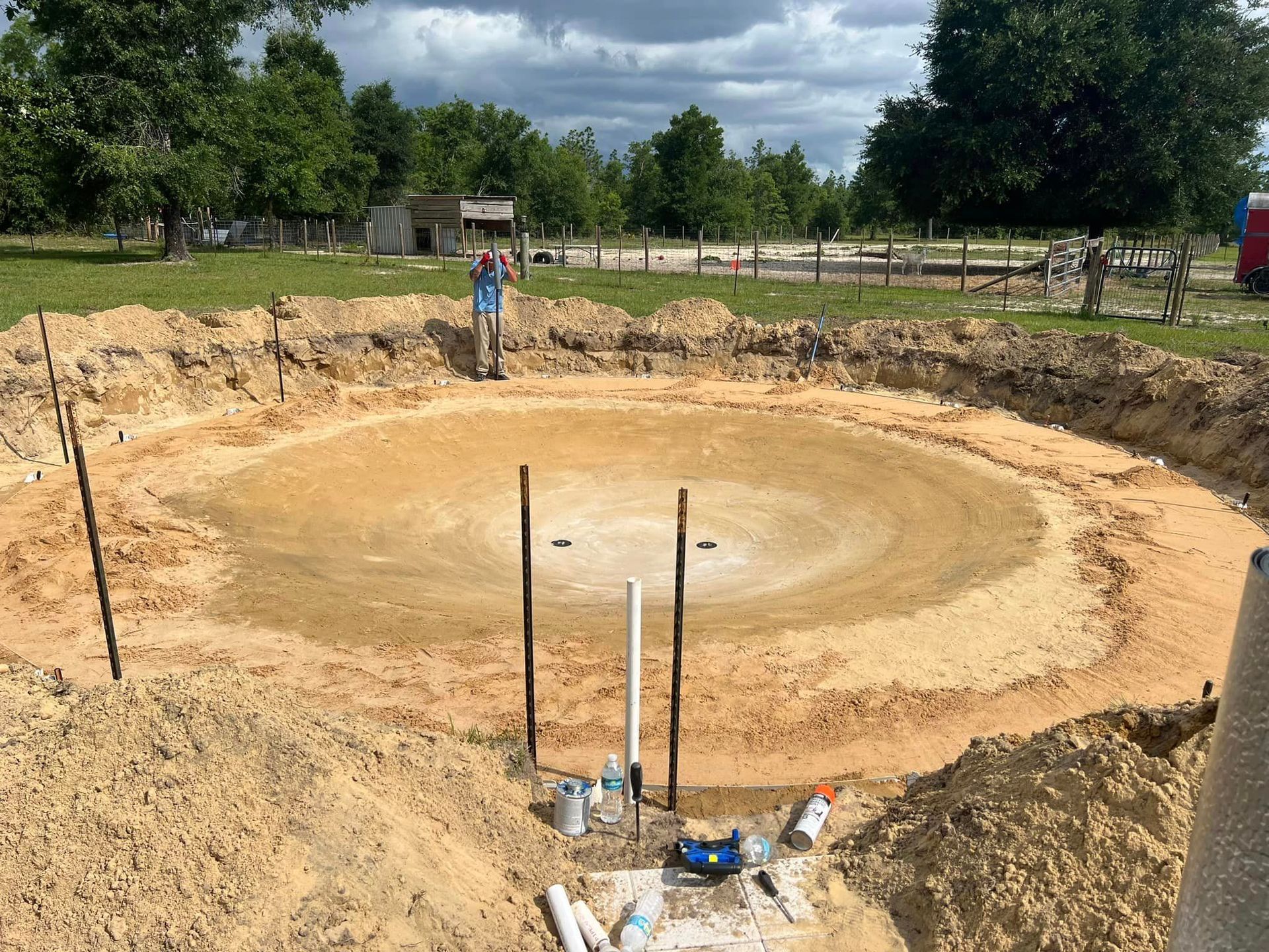 A man is standing in the middle of a large hole in the ground.