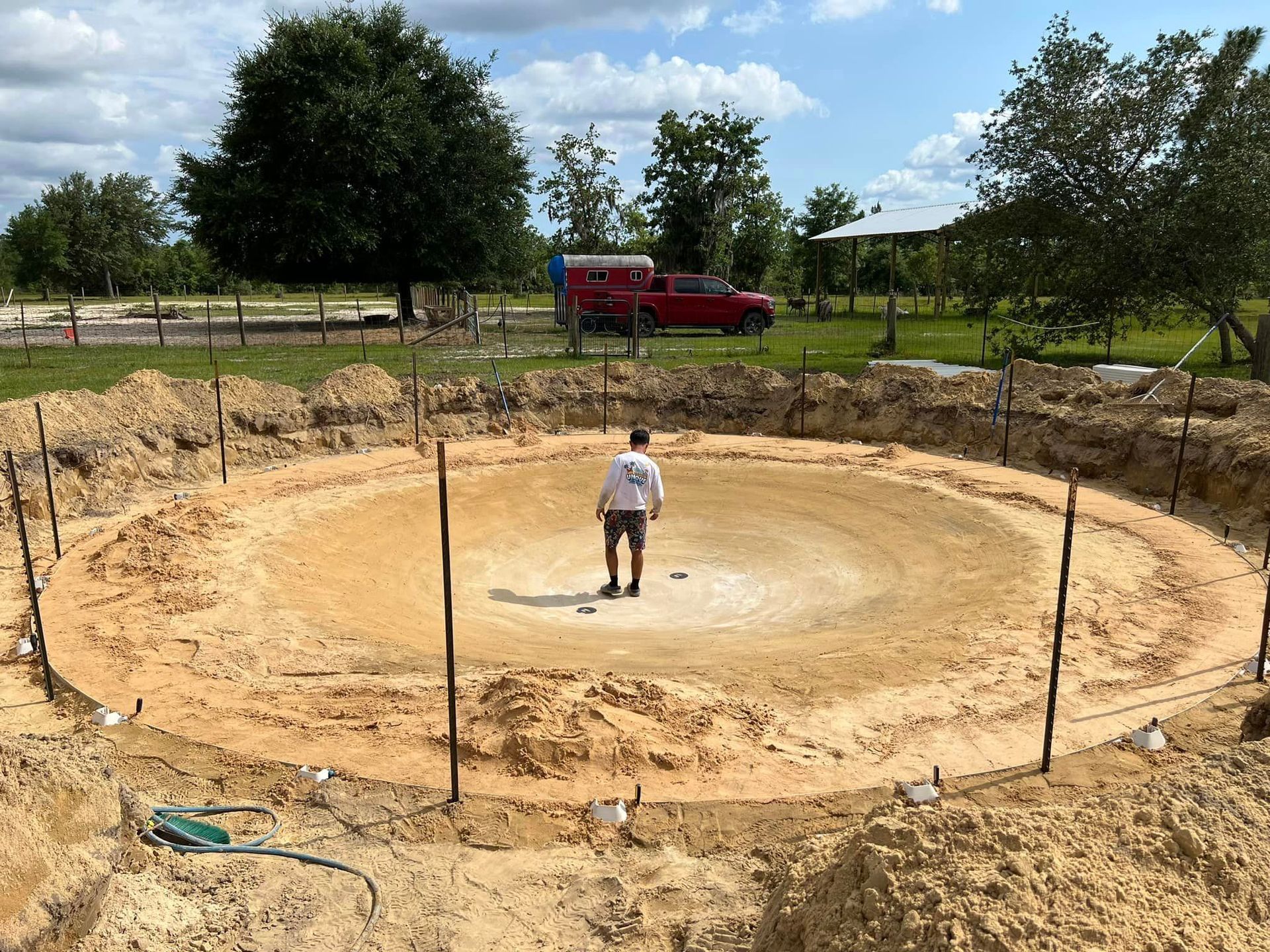 A man is standing in the middle of a circle of dirt.