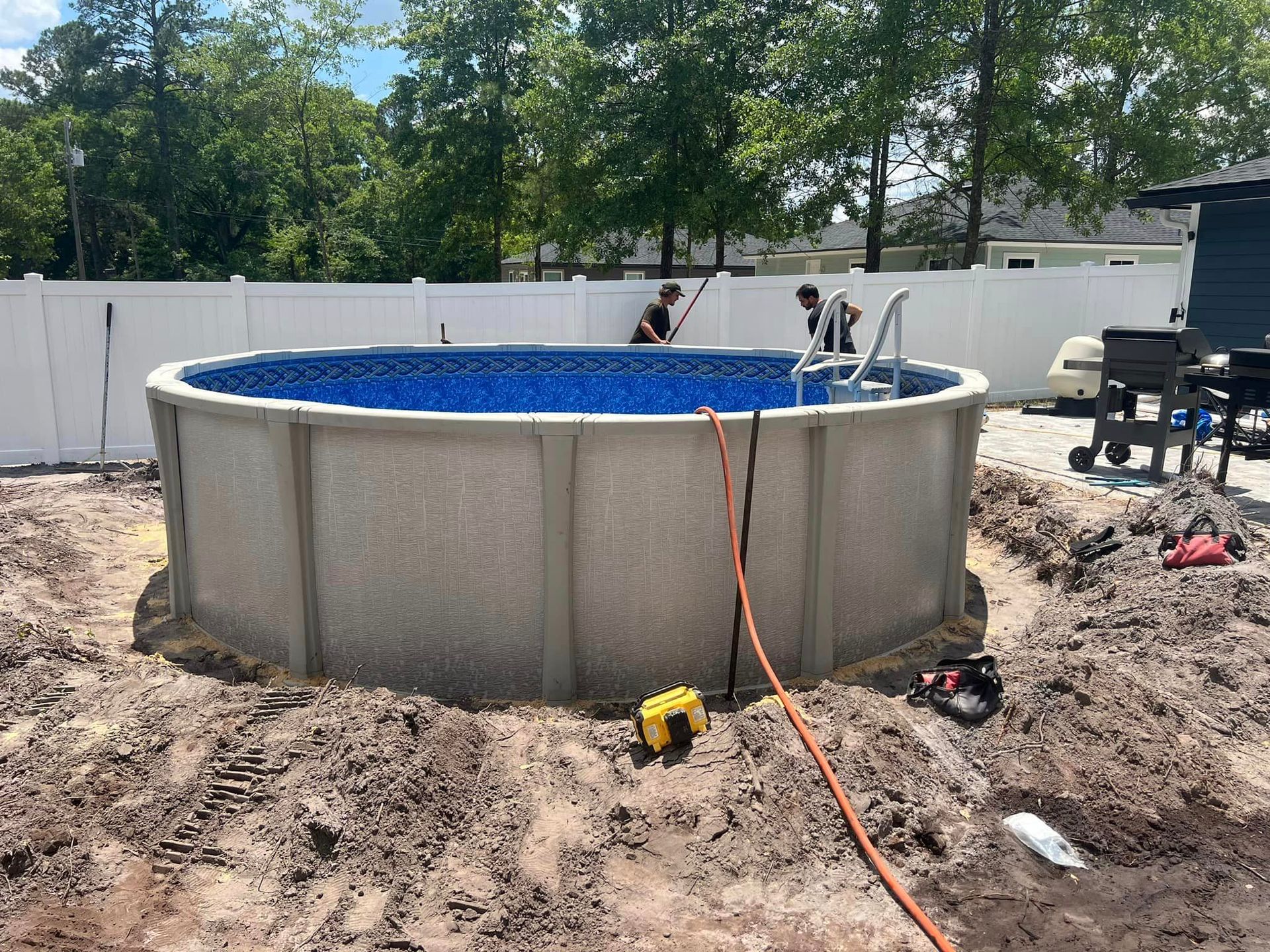 A large swimming pool is being built in a backyard.