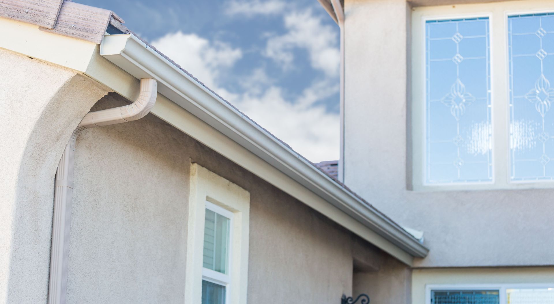 A house with a gutter on the side of it and a window.