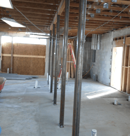 A building under construction with a wheelbarrow in the middle