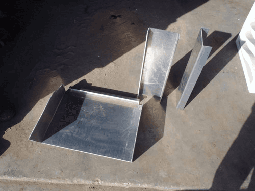 A metal tray is sitting on a concrete surface