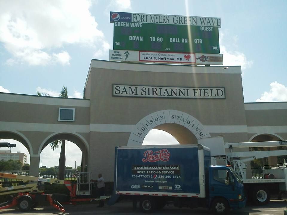 A blue truck is parked in front of sam sirianni field