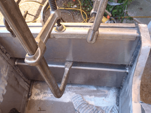 A ladder is being used to lift a piece of metal.