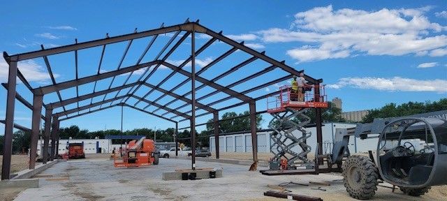 A large metal structure is being built on a sunny day.