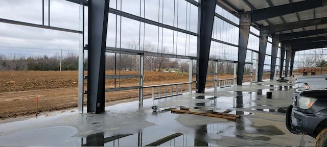 A truck is parked under a covered area in a building under construction.