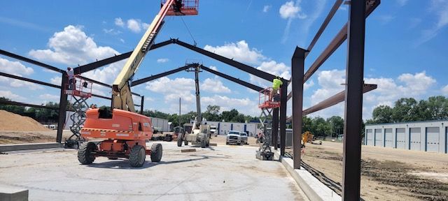 A large metal structure is being built on a construction site.