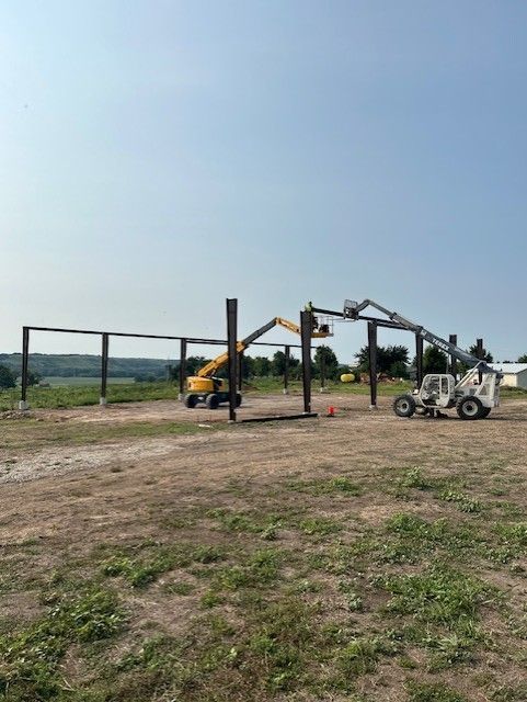 A large building is being built in a field.