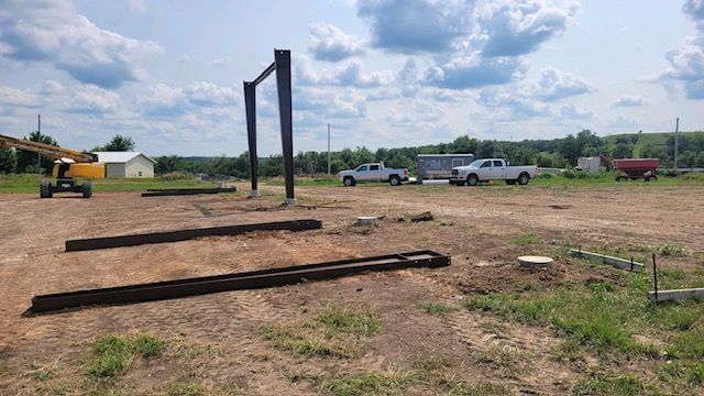 A group of trucks are parked in a dirt field.