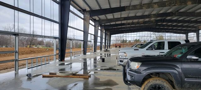 A row of trucks are parked in a building under construction.