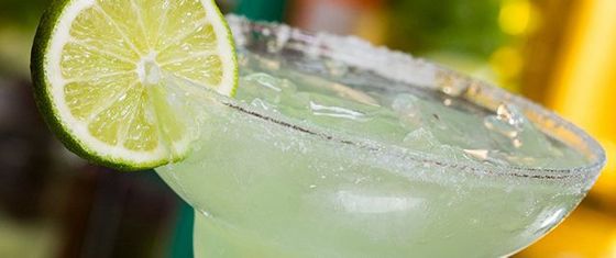 A margarita with a lime wedge and a salt-rimmed glass.