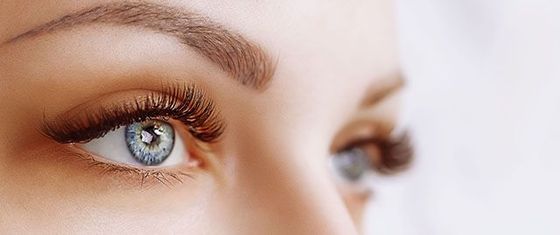 Close-up of a woman's eye with thick eyelashes.