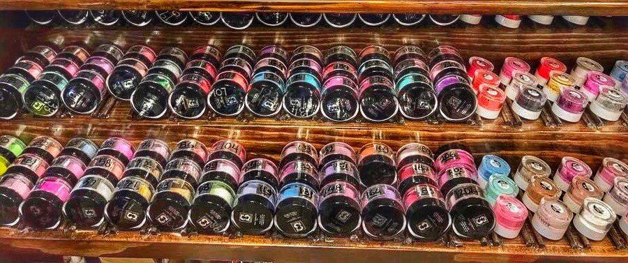 A shelf filled with lots of different colored bottles.