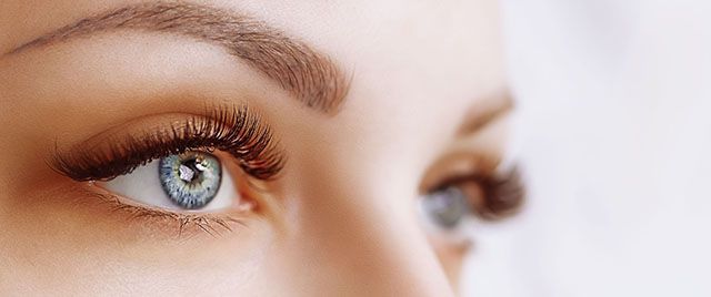 Close-up of a woman's eye with thick eyelashes.