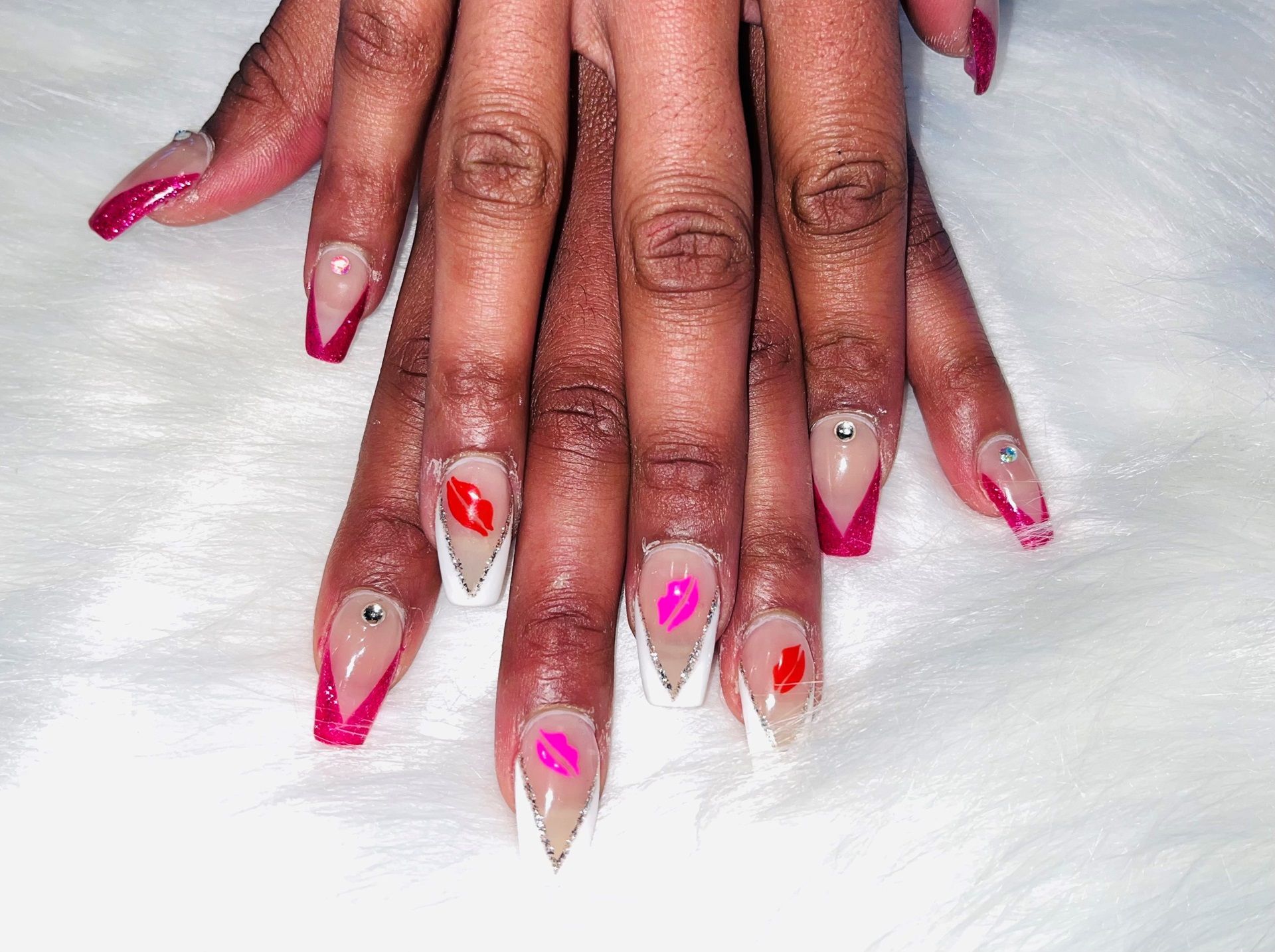 A close up of a woman's nails with a pink and red manicure design