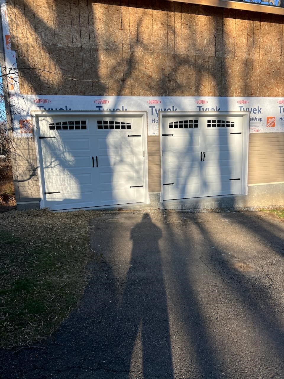 A shadow of a person is cast on a garage door.
