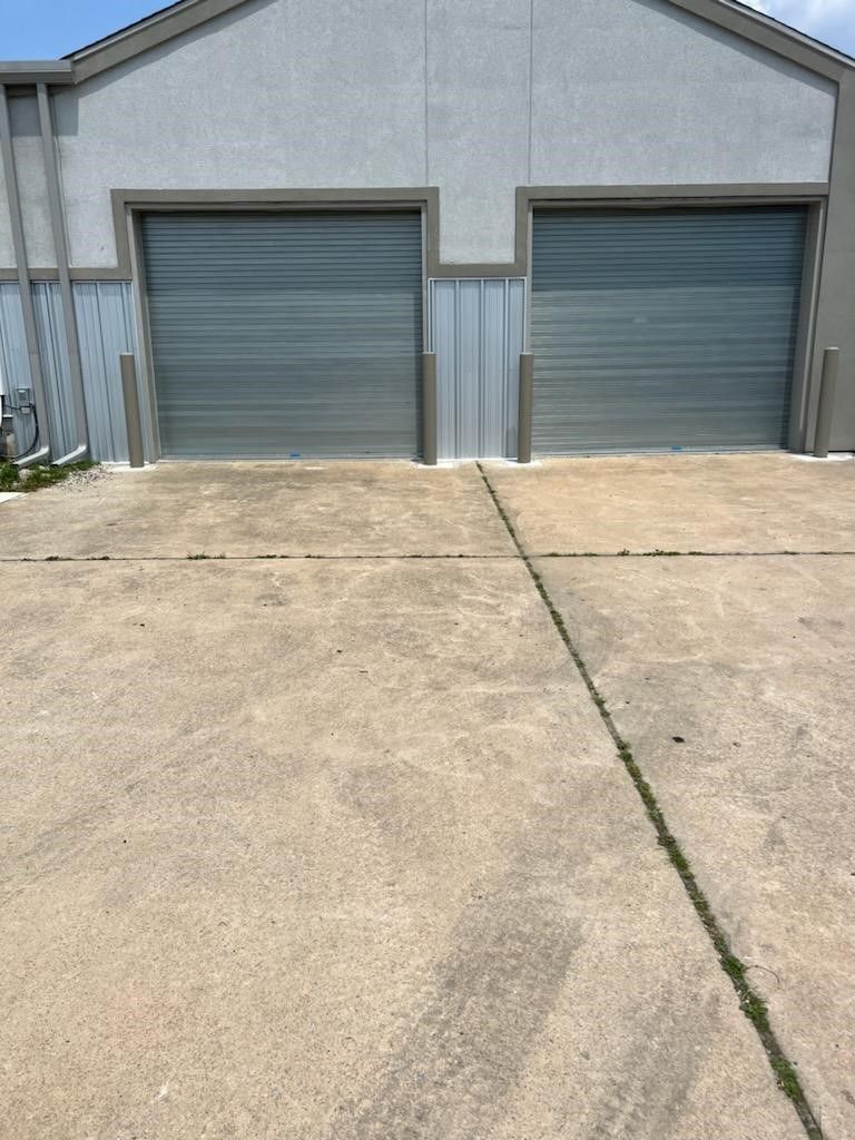 There are two garage doors on the side of a building.