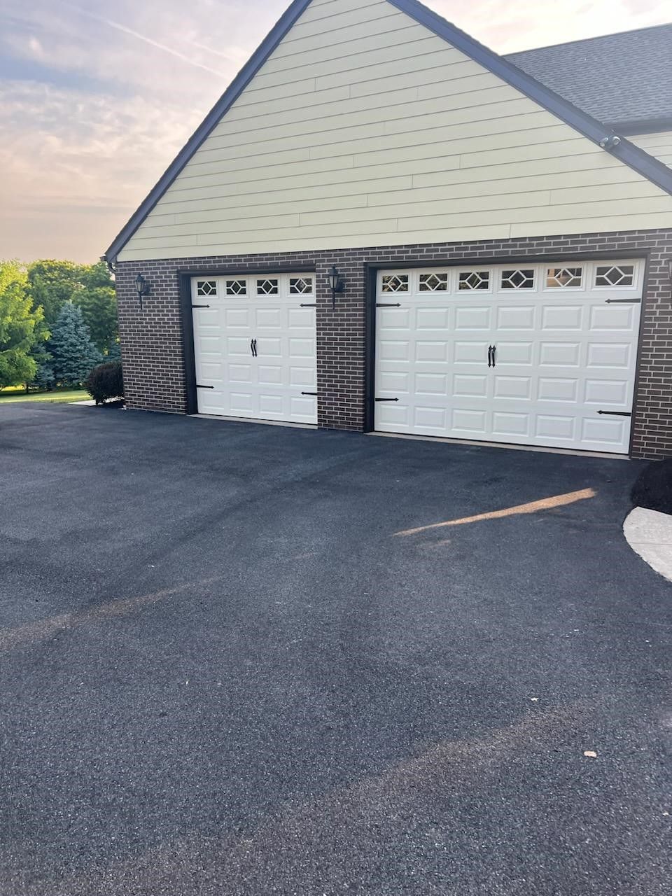There are two garage doors on the side of a house.