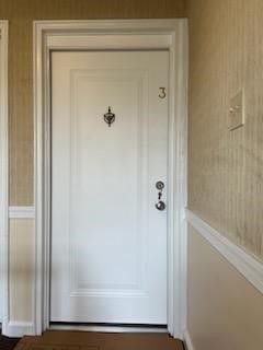 A white door with the number 3 on it is in a hallway.