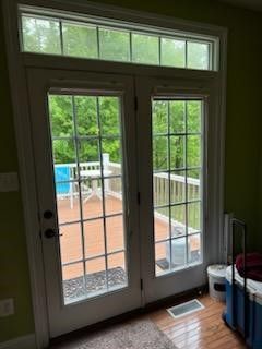 A room with a french door leading to a balcony.