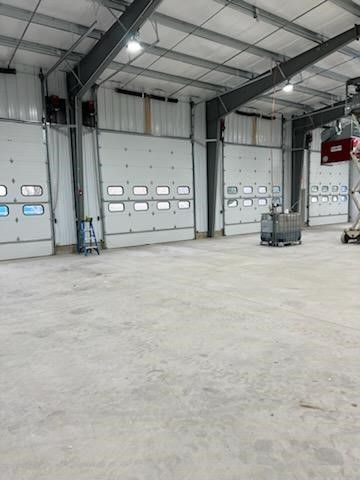 A large warehouse with a lot of doors and a concrete floor.