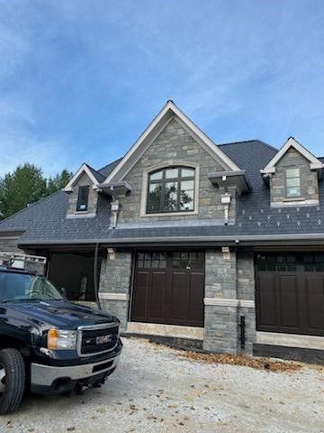 A truck is parked in front of a large house.