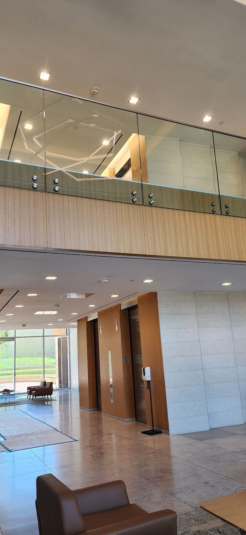 A view from a loft looking down at a colorful tiled floor area with a swing in a modern, industrial-style room.