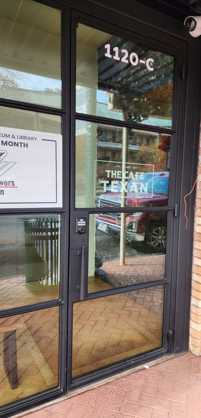 The front entrance of The Cafe Texan, featuring glass double doors marked 
